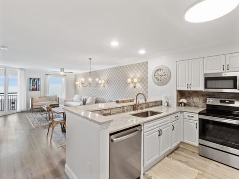Your elegant kitchen flows seamlessly into the living space, featuring granite countertops and stainless appliances perfect for preparing meals.