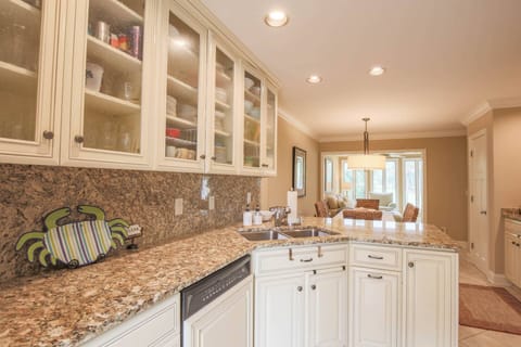 Fairway to Heaven features a renovated kitchen with white cabinetry, granite counters and tile floors.