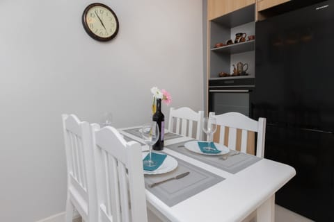 A close-up of the dining area with a white table, chairs, and decorative accents, adding charm to the kitchen space.