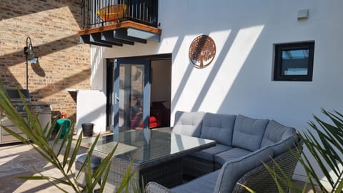 Terrace under the glass roof with dining area and BBQ