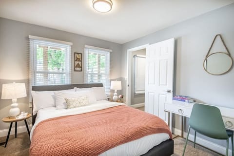 Queen bed with desk/vanity, chair and walk-in closet.