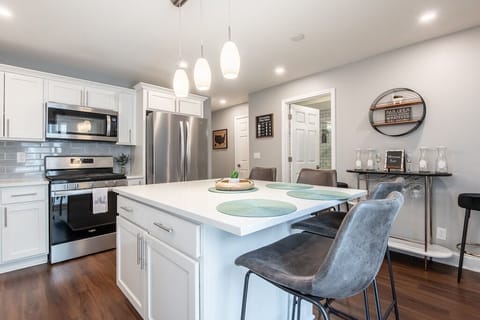 Oversized kitchen with an island and 4 bar stools. 
