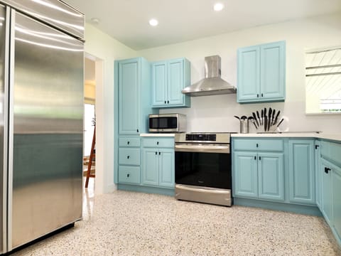 Large GE Monogram refrigerator, induction cooktop, air fryer oven and prep area.