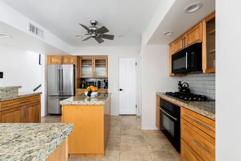 Warm wood tones and sleek granite countertops create a timeless kitchen aesthetic