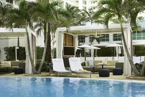 Lounge poolside in shaded cabanas with breezy tropical calm.