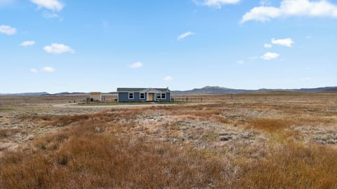 Secluded modern cabin set against open prairie and mountain backdrops