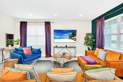 Our jewel toned living room boasts plenty of comfortable seating & a 75" TV