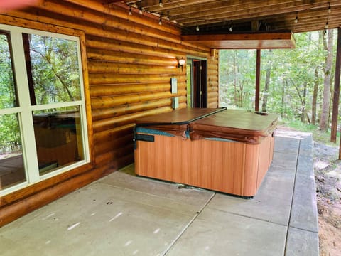 Hot tub on rear patio at basement level overlooking lake and woods.