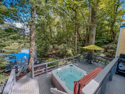 View from the back deck overlooking the hot tub, patio set, and fire pit.