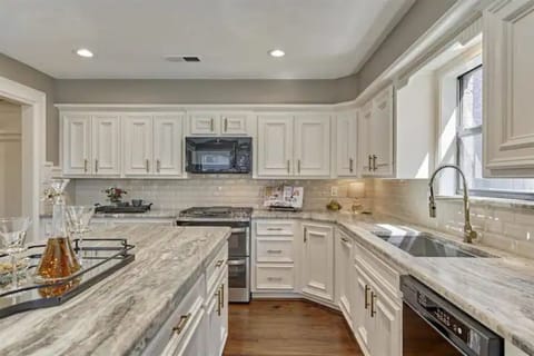 Modern kitchen with large island, breakfast bar, and leathered granite counters