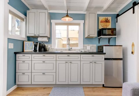 Kitchenette includes a sink, induction stove top, microwave, mini fridge, toaster, and Keurig coffee machine with coffee pods, cream, and sugar. Fully stocked with cookware and dishes. (Please note there is no oven)