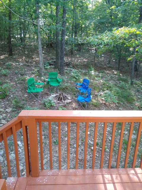 Upper deck surrounded by forest and view of the fire pit.