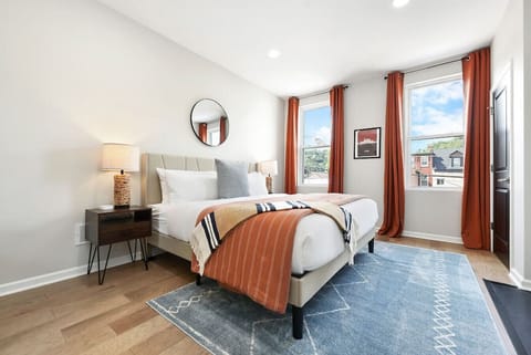 Bright primary bedroom with plush bedding and city views