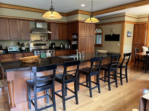 Kitchen fully stocked with plates, cups, utensils, pots, pans, small appliances.