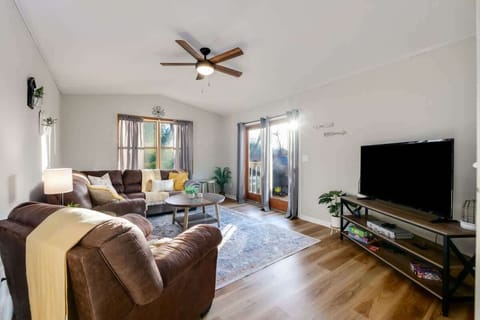 - Bright living room with large windows and natural light - Cozy sectional seating with TV for family entertainment - Easy access to outdoor deck with peaceful water views