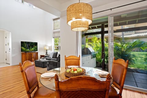 Dining area open to living room space, with BBQ and lanai nearby.