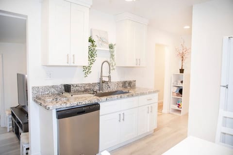 The newly renovated kitchen is sunlit from the large glass door looking out onto the pool and waterfall.