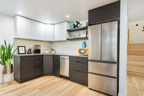 A cozy kitchenette with a fridge, dishwasher, microwave, hot plates, and an air fryer—ideal for simple meals and reheating your take-home treats from Portland's stellar dining scene!