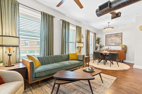Relax in style in this mid-century inspired living room featuring rich wood tones, chic decor, and abundant natural light — perfect for unwinding after exploring Kansas City.