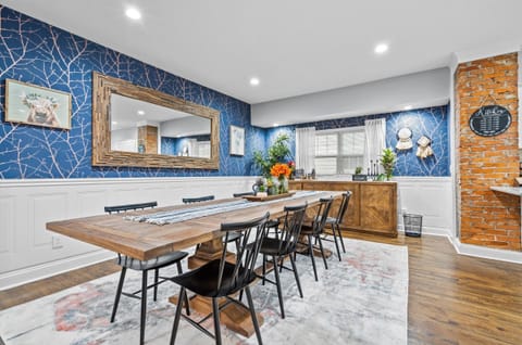 Stunning dining room with seating for the whole group, featuring bold blue accent walls and warm wood details—perfect for memorable meals in Midtown KC.