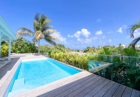 Discover our luxury villa in the West Indies, offering breathtaking views of the sparkling pool and the famous Saint-François international golf course. Enjoy moments of relaxation on the spacious wooden terrace, surrounded by majestic coconut palms. Let yourself be seduced by the elegance and comfort of this exceptional residence, nestled in the heart of a heavenly setting.