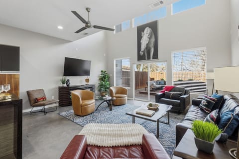 Bright and comfortable living room with a Smart TV for streaming your favorites, a cozy leather couch and sofa, and plenty of space to relax, unwind, or gather together after a full day out.