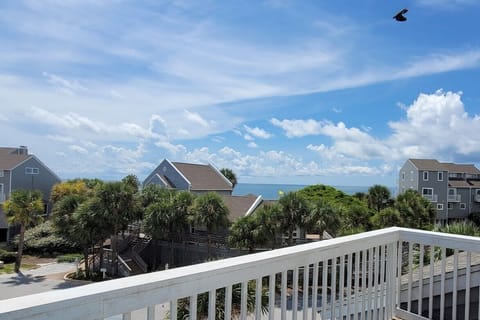 Step out here your first morning — Gulf through the palms, salt air, the whole week still ahead of you.