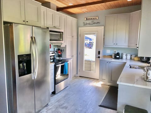Kitchen  with full size fridge, stove and dishwasher. Opens to sunny patio