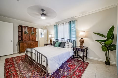 Primary bedroom view with king-sized bed, armoire, ensuite bathroom 