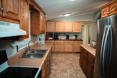 Kitchen area with stove, refrigerator, dishwasher, microwave and coffee bar