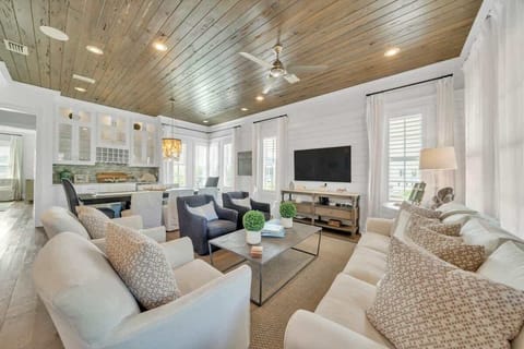 - Relax in this bright, open concept living room with cozy seating, modern coastal décor, and tons of natural light - Wood paneled ceiling adds warmth and character to the space - Wall mounted smart TV perfect for family movie nights or game time