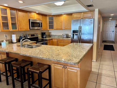Three barstools provide additional seating at the kitchen counter. 
