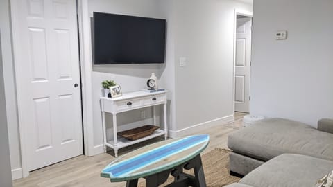 Living room with surfboard table and big screen TV with Cable, Internet & WiFi