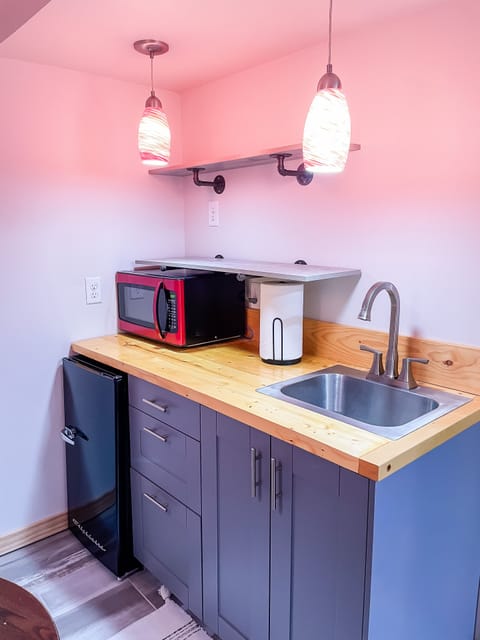 Wet bar located in the basement with mini fridge, microwave, sink & seating area