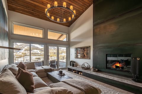 Sink into plush cushions by your crackling fireplace, where mountain views create the perfect backdrop for cozy evenings.
