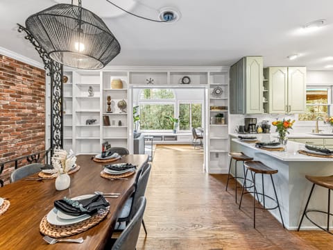 Semi-open layout with multiple dining spaces in dining room, kitchen, and sunroom