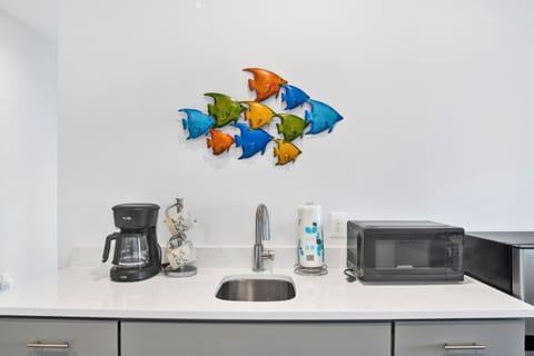 The kitchenette features a sink, mini fridge, microwave and coffee maker