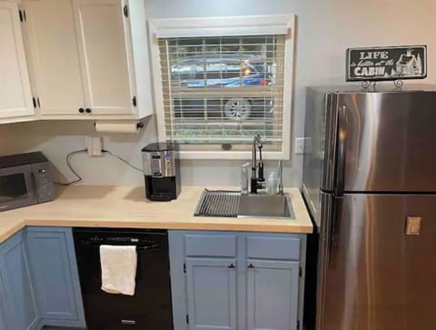 Dishwasher and refrigerator with view of the front of the house