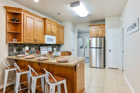 4 beautiful bar chairs line the kitchen counter side, overlooking the fully functional kitchen space
