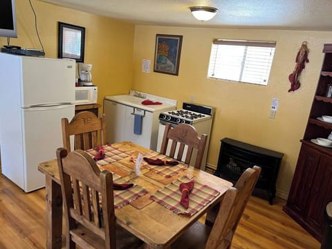 Dining area and small kitchen stocked with cooking and eating amenities. You just bring the food!