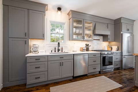 Your sleek gray kitchen features modern appliances and elegant glass-front cabinets, perfect for preparing memorable meals during your stay.