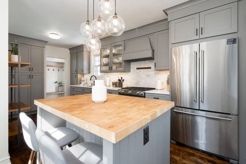 Your gourmet kitchen awaits with butcher block island, pendant lighting, and stainless steel appliances for memorable meal prep.