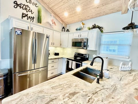 Whip up fresh meals in a coastal-chic kitchen featuring stainless steel appliances and quartz counters.