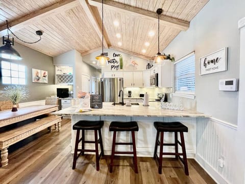 Gather around the island in this modern kitchen with open beams and casual seating.