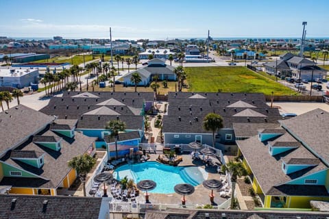 📍 Bird’s-eye view of paradise! Take a dip in our sparkling pool surrounded by cozy cottages and palm trees.