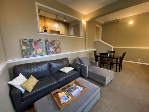 Comfortable living room with TV and dining area has high ceilings. 