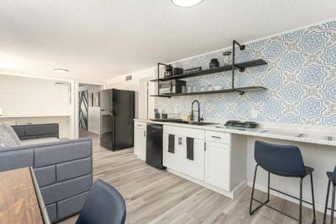 kitchen with cabinets, small two-place stove, fryer,refrigerator and slow cooker with microwave oven