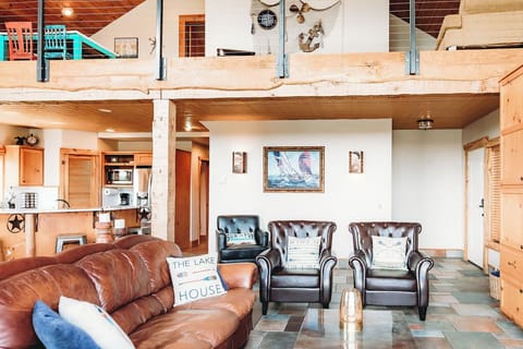 Living Room: Gather in style with leather seating and artistic lake views for unforgettable moments!