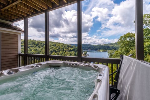 Private deck off of the primary bedroom with hot tub overlooking Lake Glenville