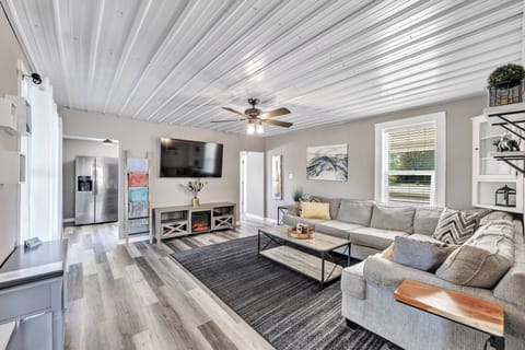 Living room with large sectional for amble seating, electric fireplace, 65in TV.